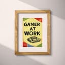 Matted frame view of A retro linocut print, the words "GAMER AT WORK" with a game controller