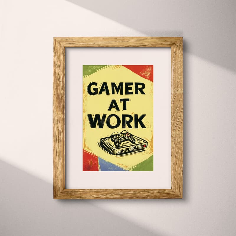 Matted frame view of A retro linocut print, the words "GAMER AT WORK" with a game controller