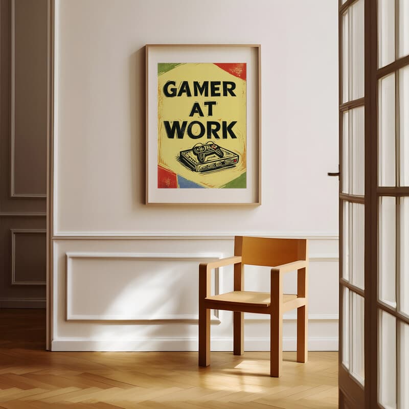 Room view with a matted frame of A retro linocut print, the words "GAMER AT WORK" with a game controller