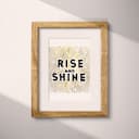 Matted frame view of A minimalist linocut print, the words "RISE AND SHINE"