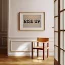 Room view with a matted frame of A retro letterpress print, the words "RISE UP"