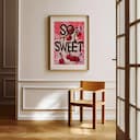 Room view with a matted frame of A vintage linocut print, the words "SO SWEET" with cherries