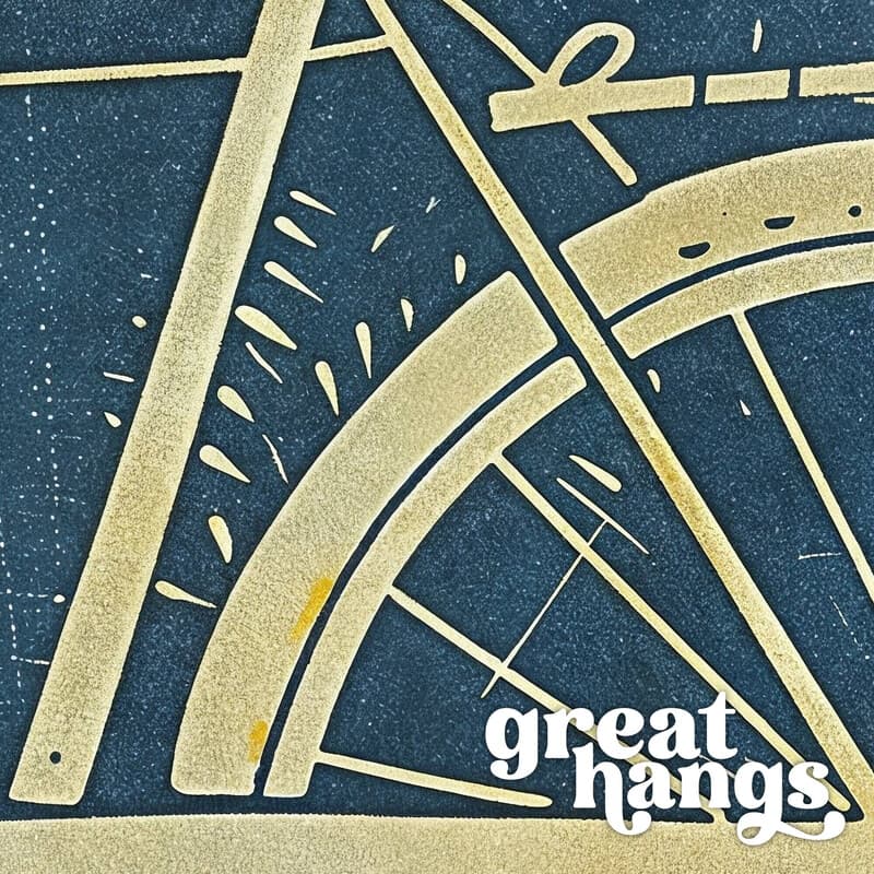 Closeup view of A vintage linocut print, the words "BE GREAT" with a bicycle