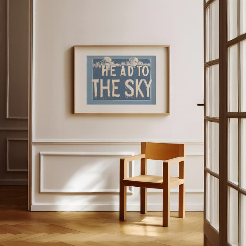 Room view with a matted frame of A vintage linocut print, the words "HEAD TO THE SKY" with clouds