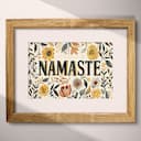 Matted frame view of A botanical linocut print, the words "NAMASTE" with a floral pattern