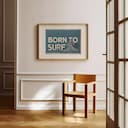 Room view with a matted frame of A vintage linocut print, the words "BORN TO SURF" with a wave