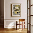 Room view with a matted frame of A vintage linocut print, the words "KEEP DREAMING" with a whimsical pattern