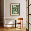 Room view with a matted frame of A vintage linocut print, the words "ROLL WITH IT" with a roll of toilet paper